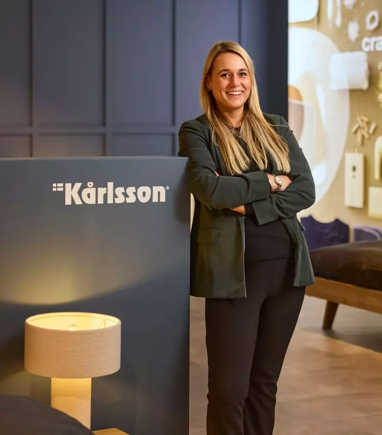 Man is vrolijk een winkelschap met kleding aan het inruimen.